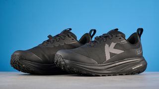 Keen Roam train running shoes in black photographed in front of a blue background