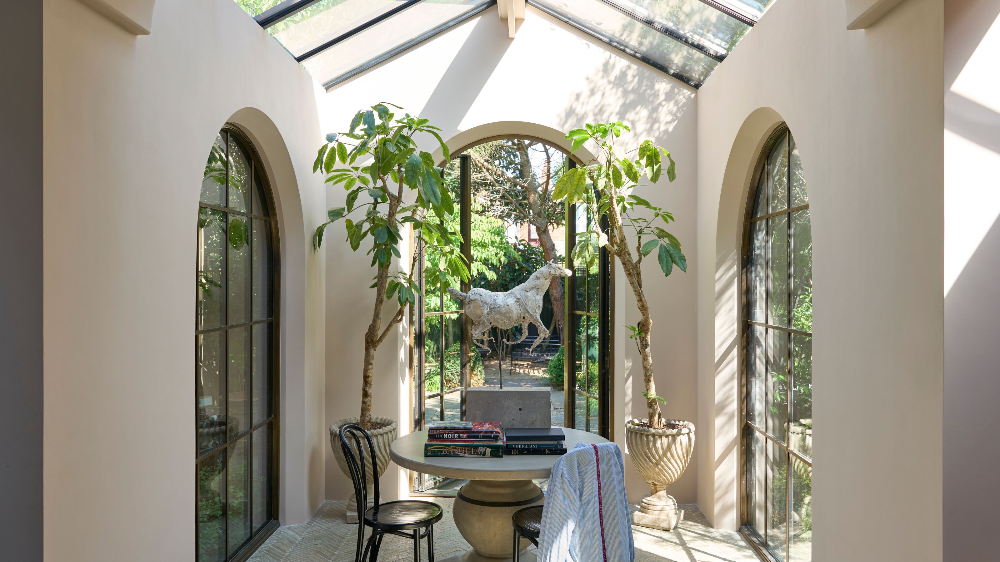 light and airy conservatory with three arched windows and skylights with warm neutral walls