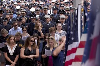 Firefighters and their families attend a ceremony at the Firefighters Memorial on September 11, 2011 in New York.