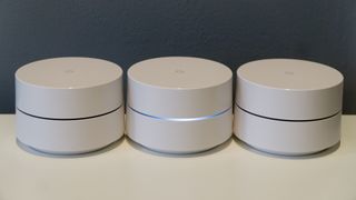 A 3-Pack Of Google Wifi Network Access Points Lined Up On An Office Table