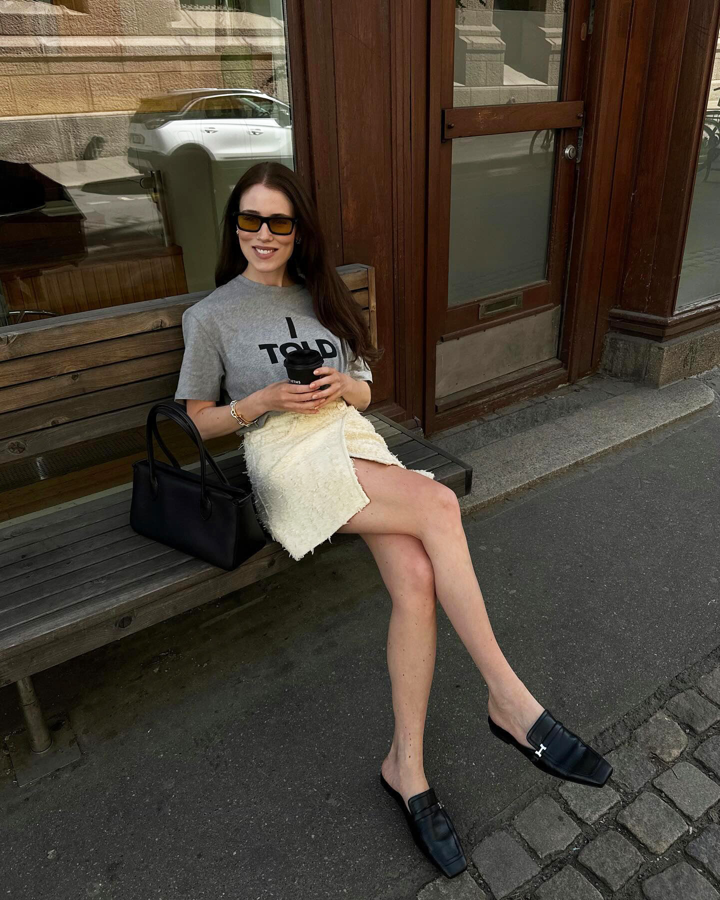 Woman wearing a grey T-shirt, miniskirt, and loafers