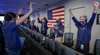 Members of NASA’s Perseverance rover team react in mission control after receiving confirmation the spacecraft successfully touched down on Mars, Thursday, Feb. 18, 2021, at NASA's Jet Propulsion Laboratory in Pasadena, California. The team is masked and distanced with accordance to COVID-19 safety precautions.