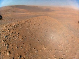 an aerial photograph of the surface of Mars with Perseverance rover in the background