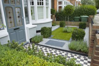 traditional black and white tiled path in a modern front garden