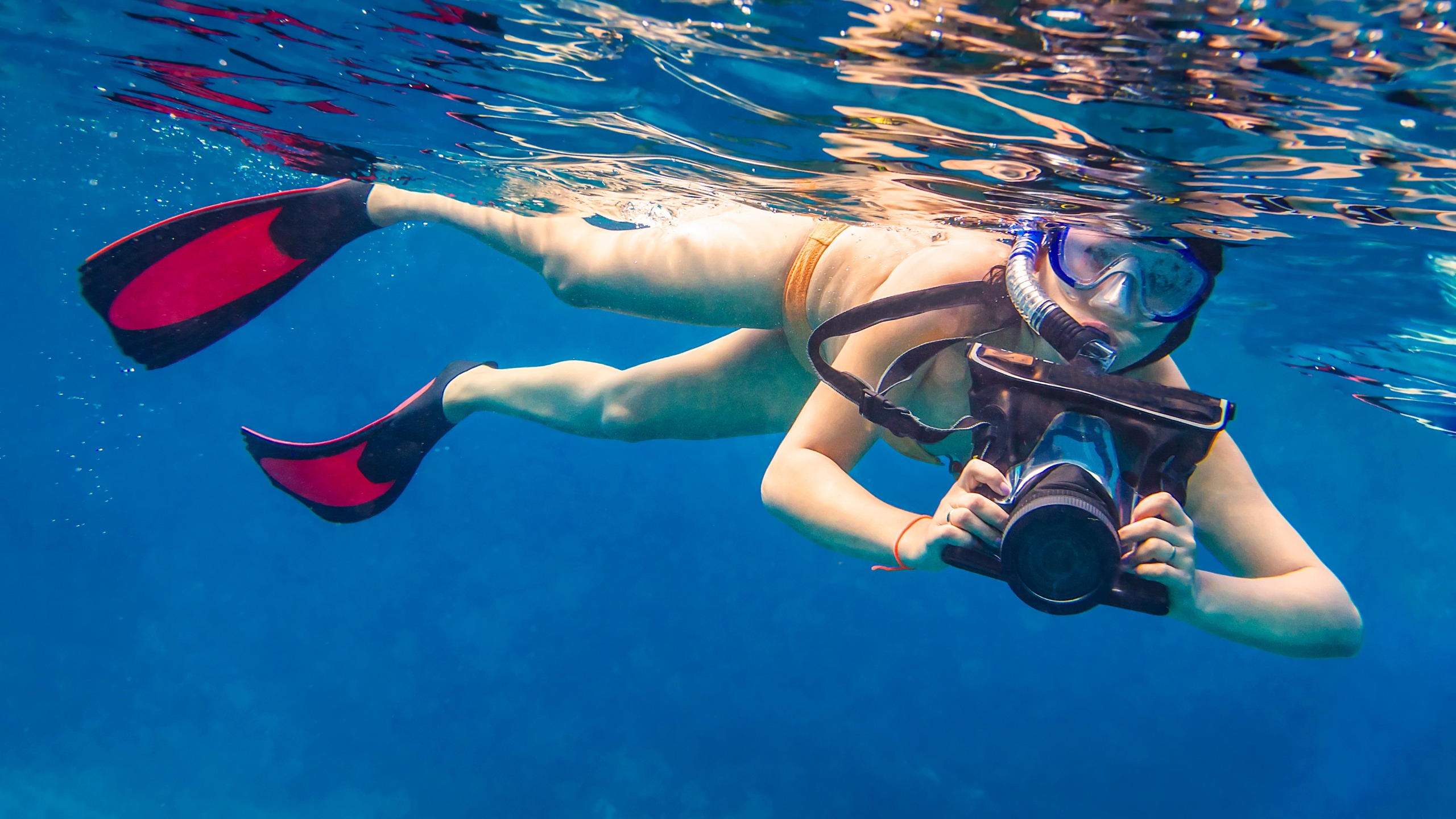 Woman snorkelling with camera in underwater housing