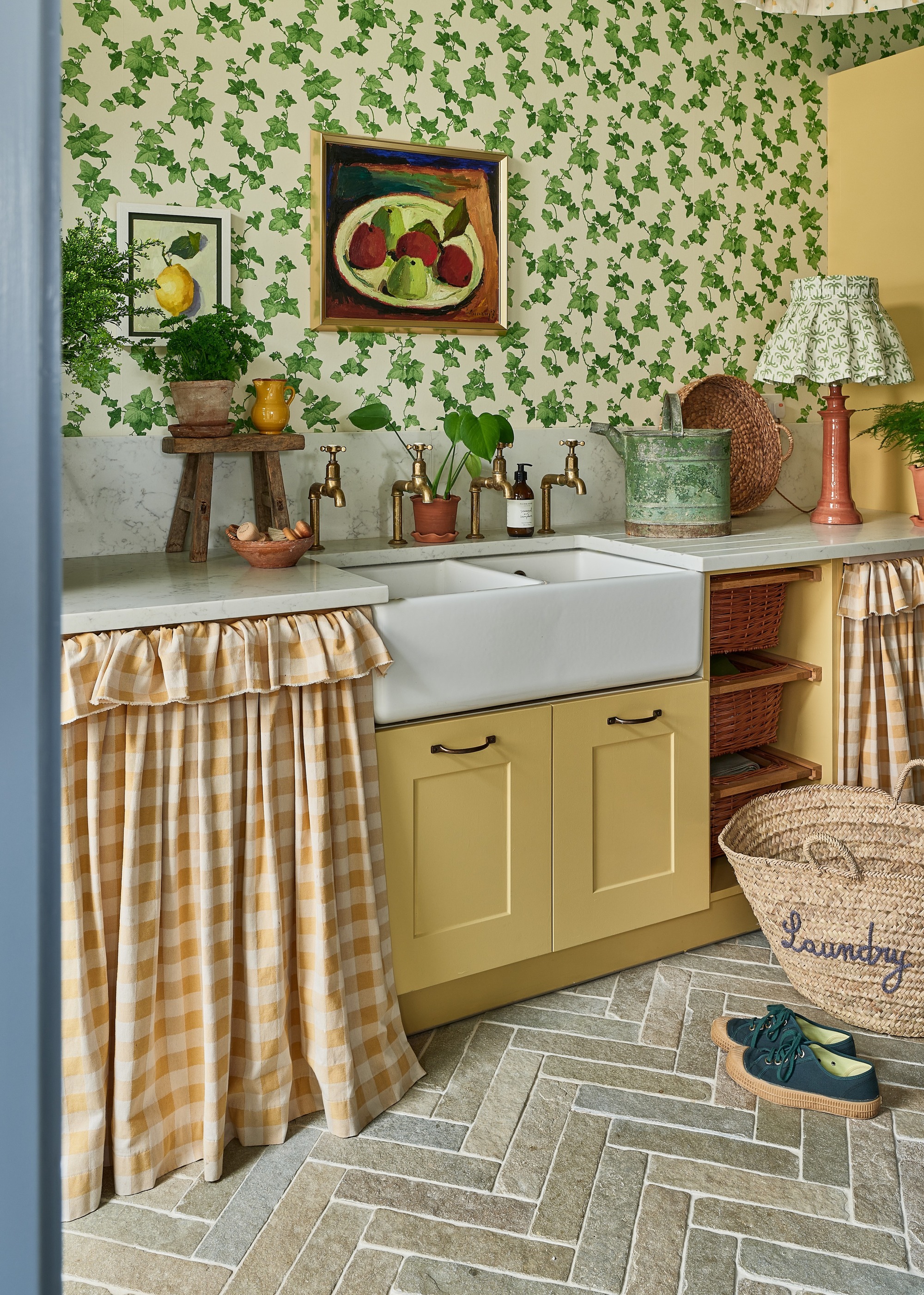 kitchen with stone herringbone tiled flooring, yellow cabinets and green wallpaper