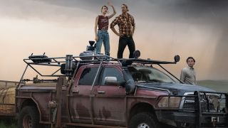 Glen Powell, Daisy Edgar-Jones And Anthony Ramos looking at a tornado from a car in the official Twisters poster.