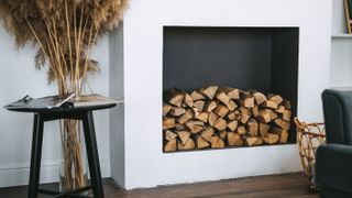 Empty fireplace with stacked logs