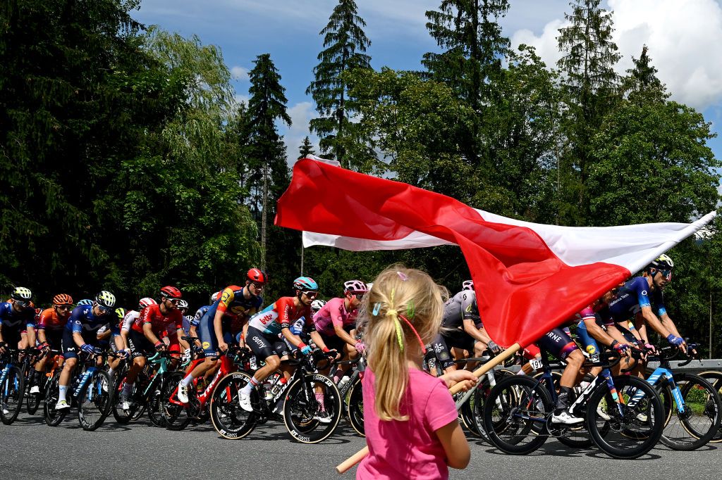 BIELSKOBIALA POLAND AUGUST 02 A girl flies the Polish flag as the peloton competes in the 80th Tour de Pologne 2023 Stage 5 a 1988km stage from Pszczyna to BielskoBiala 430m UCIWT on August 02 2023 in BielskoBiala Poland Photo by Dario BelingheriGetty Images