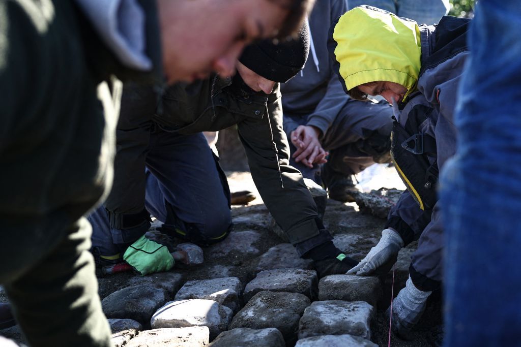 Workers repair cobblestones on the route of the ParisRoubaix cycling race near Arenberg on April 4 2023 ahead of this weekends men and women races Photo by AnneChristine POUJOULAT AFP Photo by ANNECHRISTINE POUJOULATAFP via Getty Images