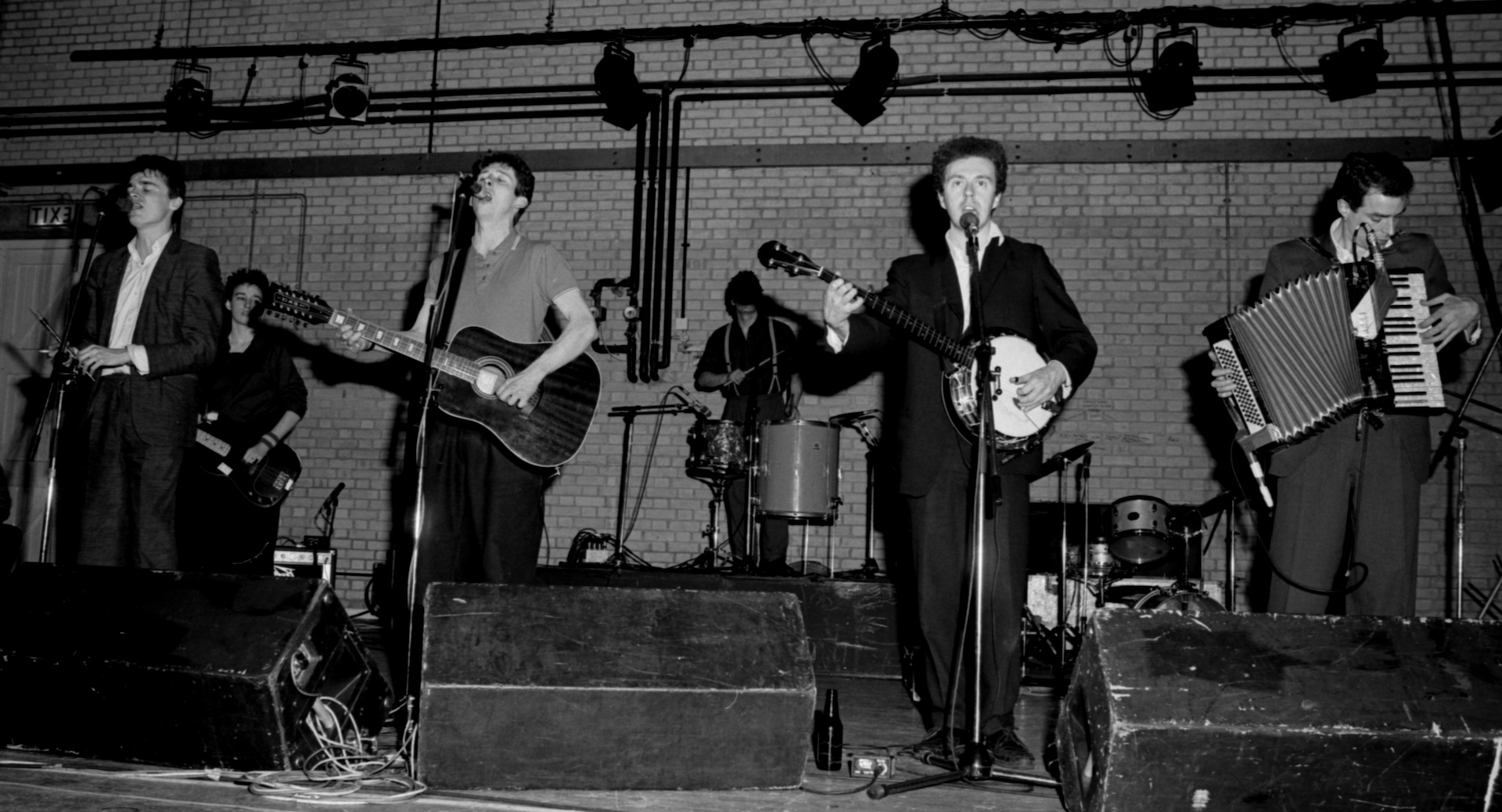 The Pogues performing live on stage in Reading, UK, 1985. Left to right: Spider Stacey, Cait O'Riordan, Shane MacGowan, Andrew Ranken (drums) Jem Finer, James Fearnley