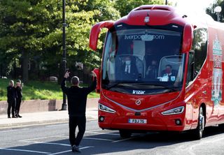 A fan gestures towards the Liverpool team coach outside the Etihad Stadium as the new Premier League champions arrived