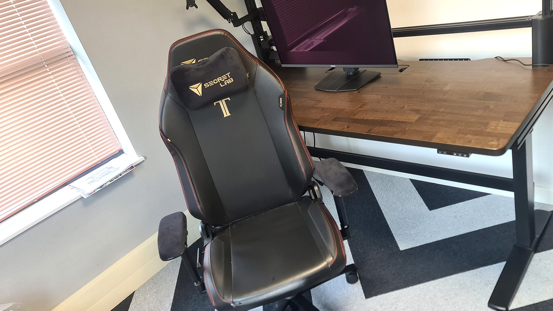 The Secretlab Titan Evo next to a desk in the PC Gamer office.