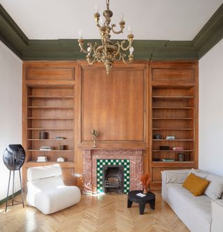 Living room with wood panelled wall and green painted coving