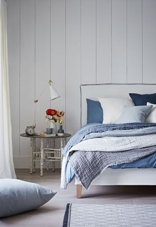 wall panelling in a bedroom with blue bedding