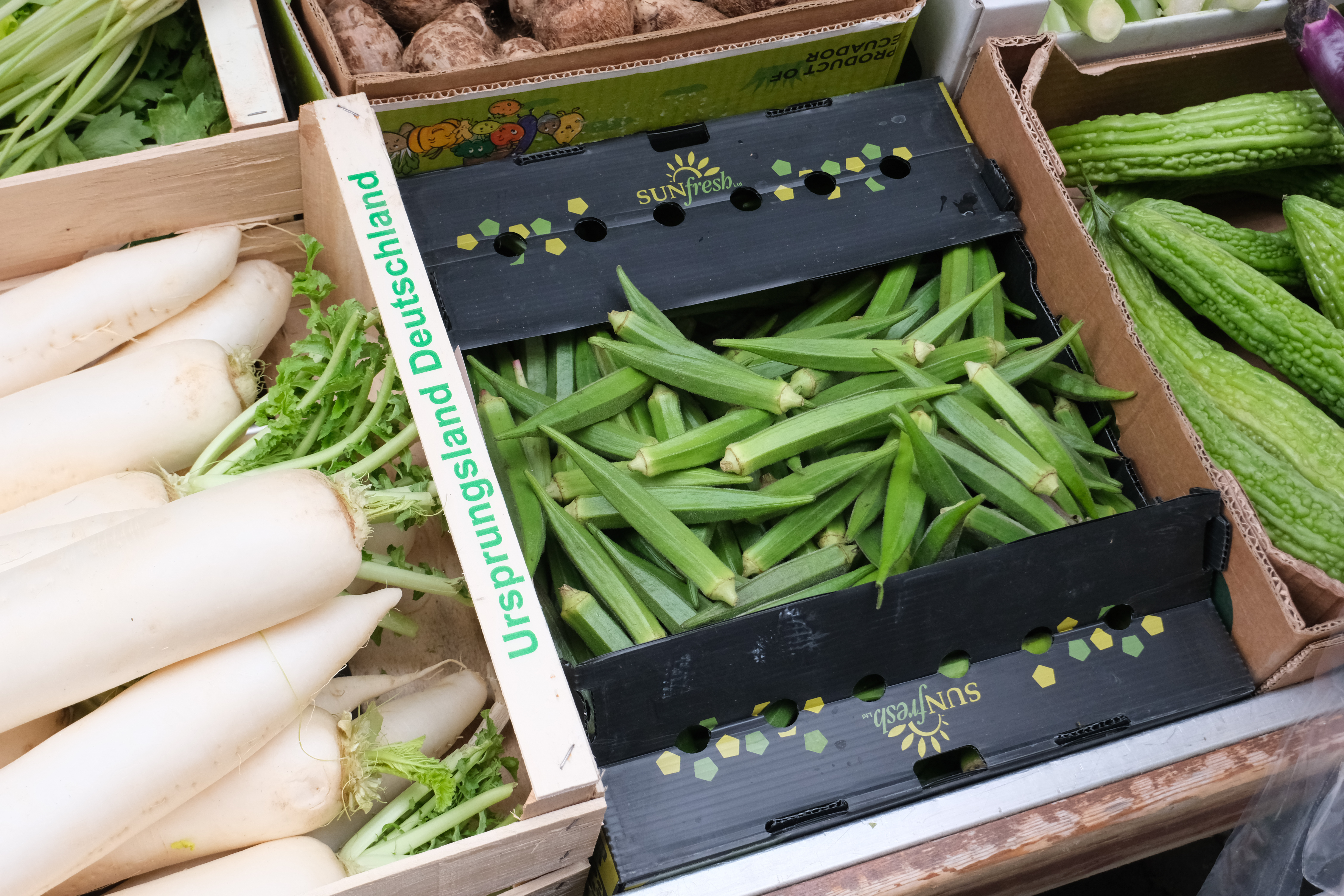 Okra and other vegetables in boxes at a market