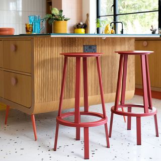 freestanding wooden kitchen island with red bar stools