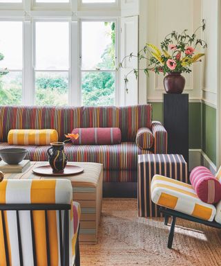 living room with striped sofa, accent chairs and ottoman and sisal rug