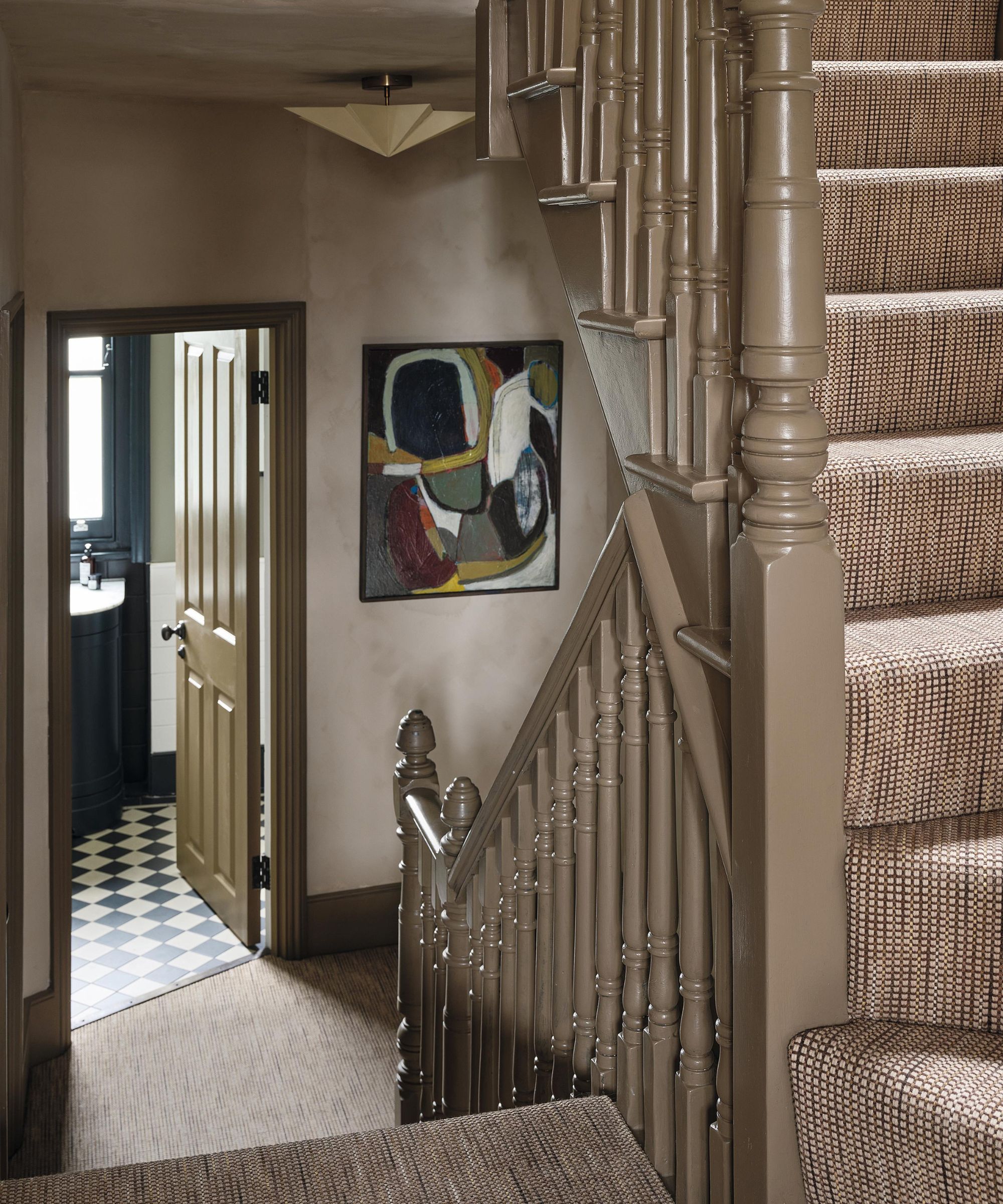 an earthy limewashed entryway and staircase in a Victorian home