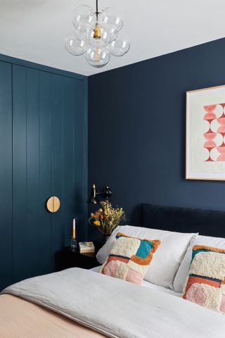 A bedroom with royal blue walls and a white, cream ceiling