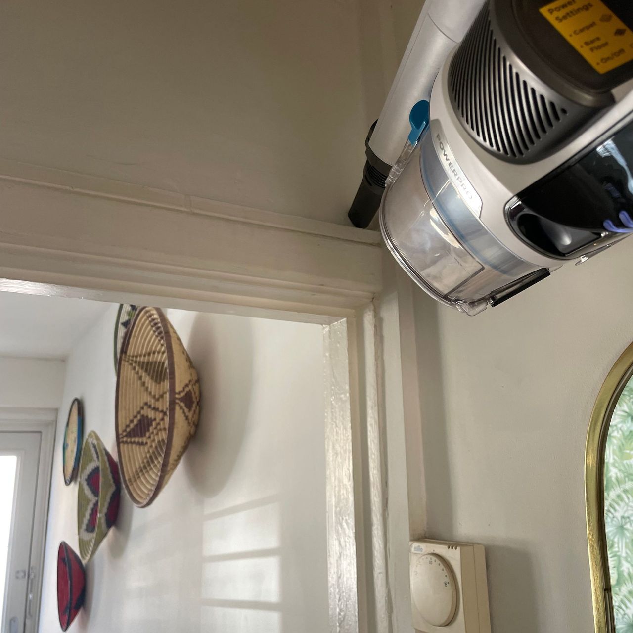 handheld Shark PowerPro Pet Cordless Stick Vacuum cleaning the tops of a doorframe