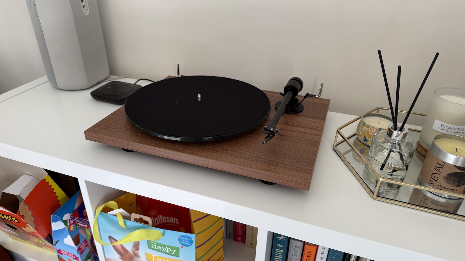The walnut-finished Pro-Ject T1 turntable, photographed on a white bookcase