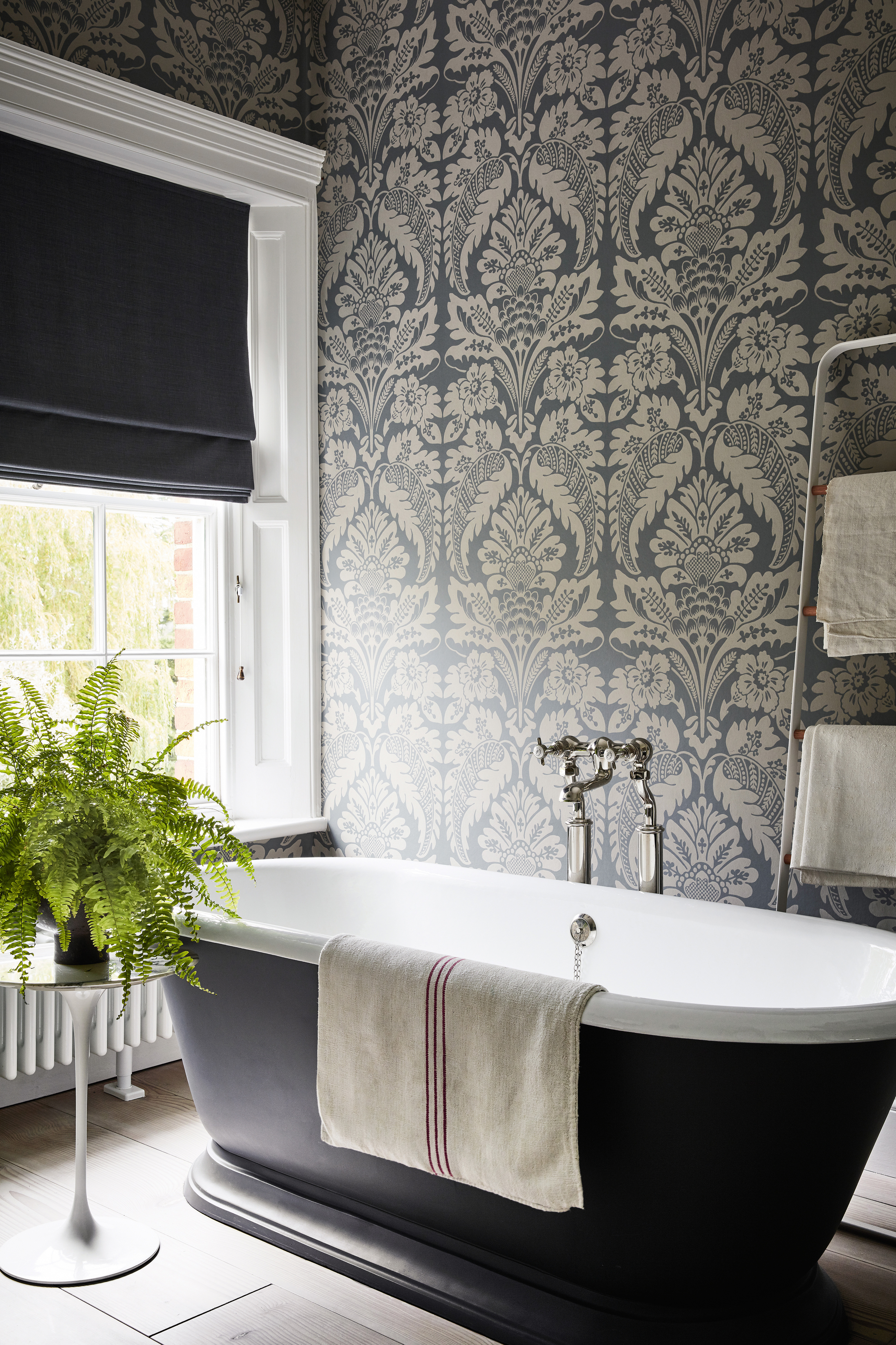 Black bathroom with rolltop bath by Little Greene