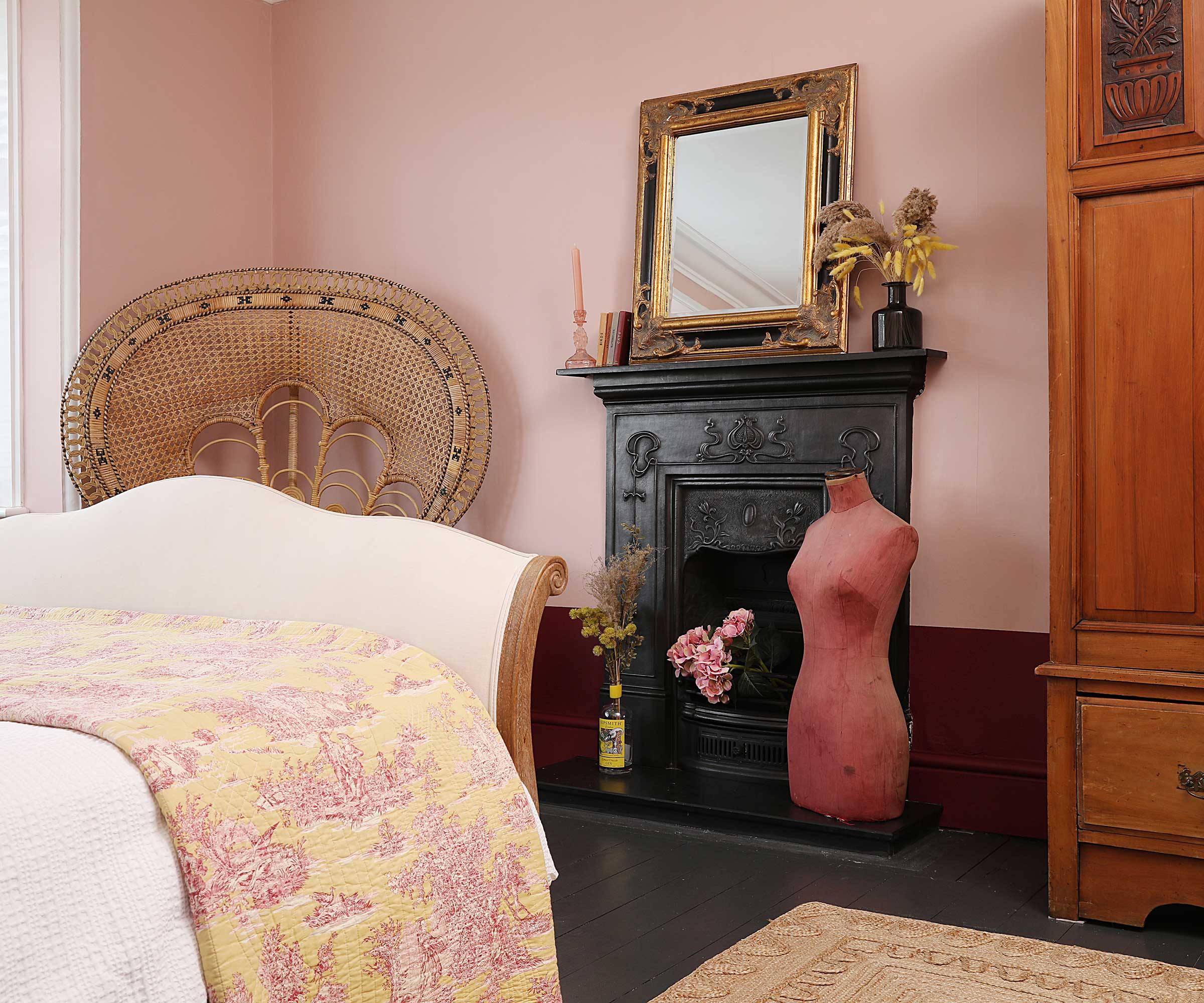 bedroom with pale pink walls and traditional fireplace