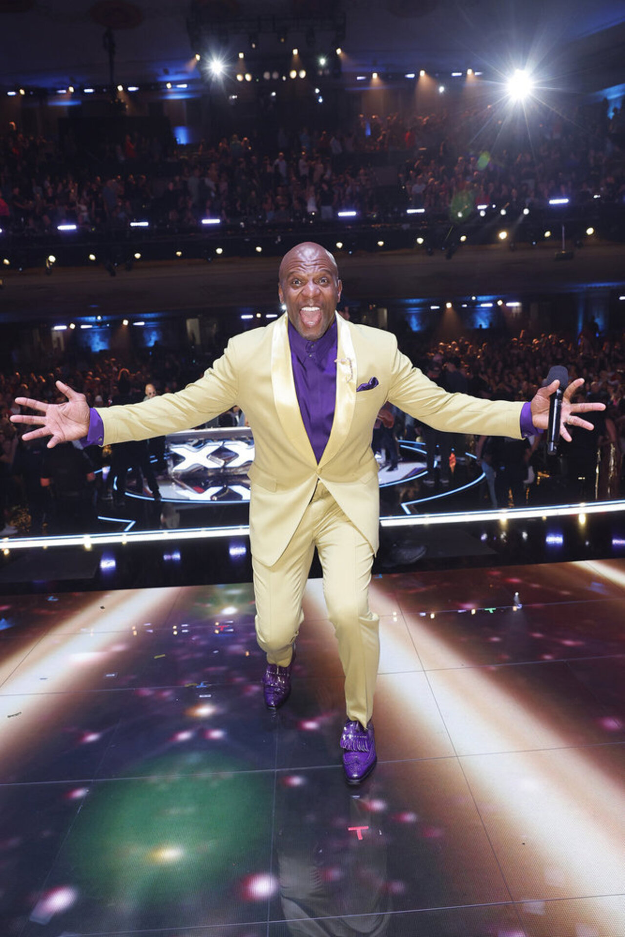 Terry Crews wearing a yellow suit and purple shirt on AGT Season 20