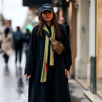 woman wearing crossbody bag, hat, green scarf