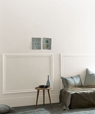 Off-white colored wall with stool and pillows