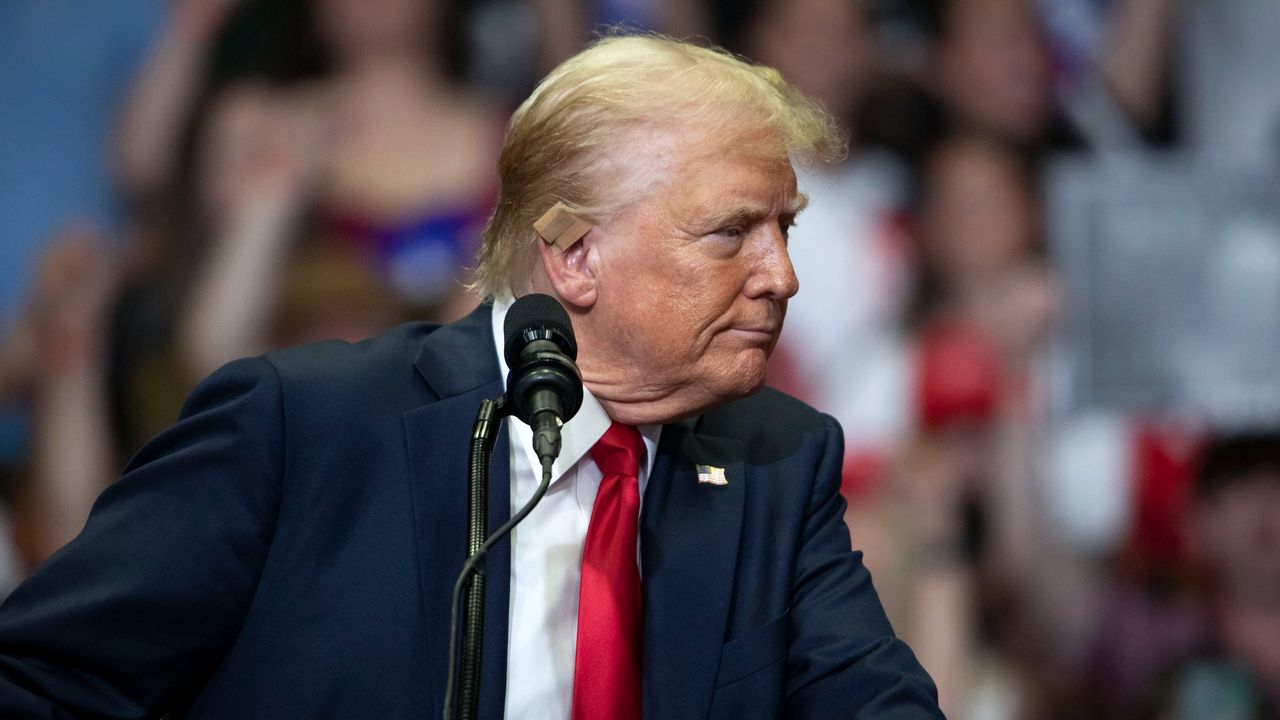 Donald Trump shows off his ear bandage at post-shooting rally in Michigan