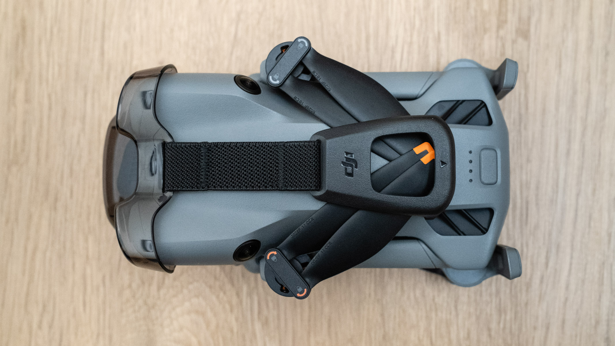 DJI Mini 5 Pro folded on a wooden floor
