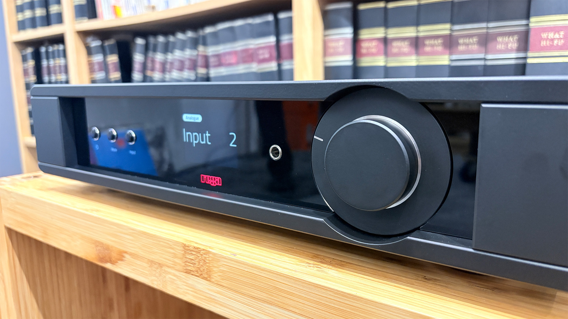 Rega Mercury preamplifier on wooden hi-fi rack in front of bookcase