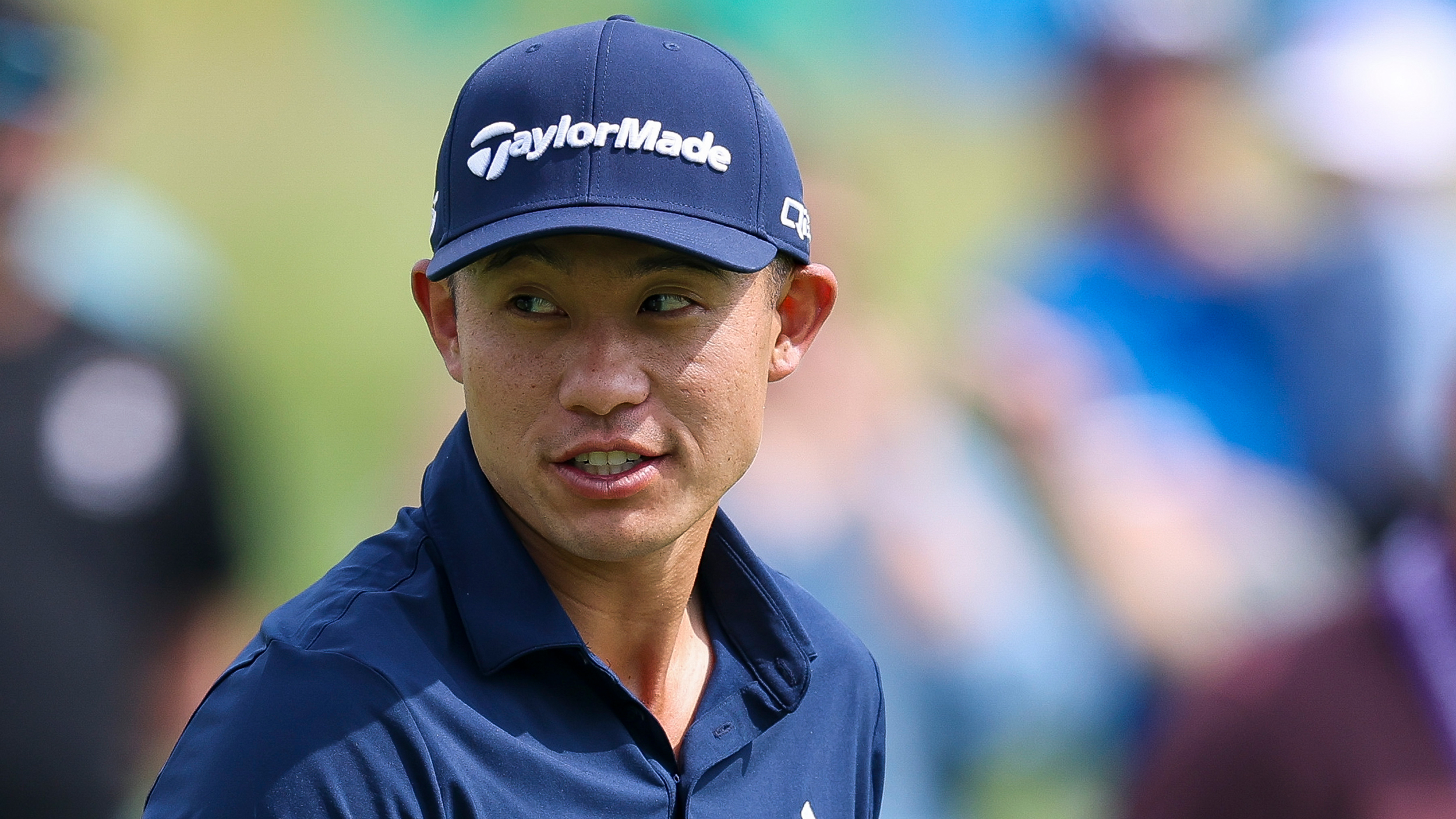 Collin Morikawa wearing a navy TaylorMade cap and navy polo