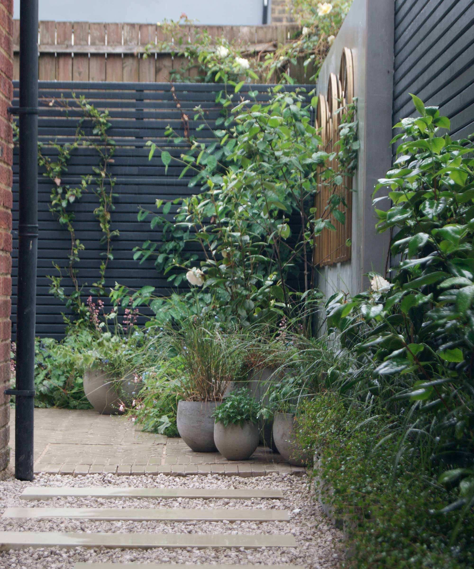 fence painted with Thorndown Paints 'Anthracite' with potted plants