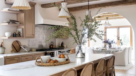 McGee & Co.'s Celia Woven tray on an island with marble countertops, surrounded by wooden cabinetry