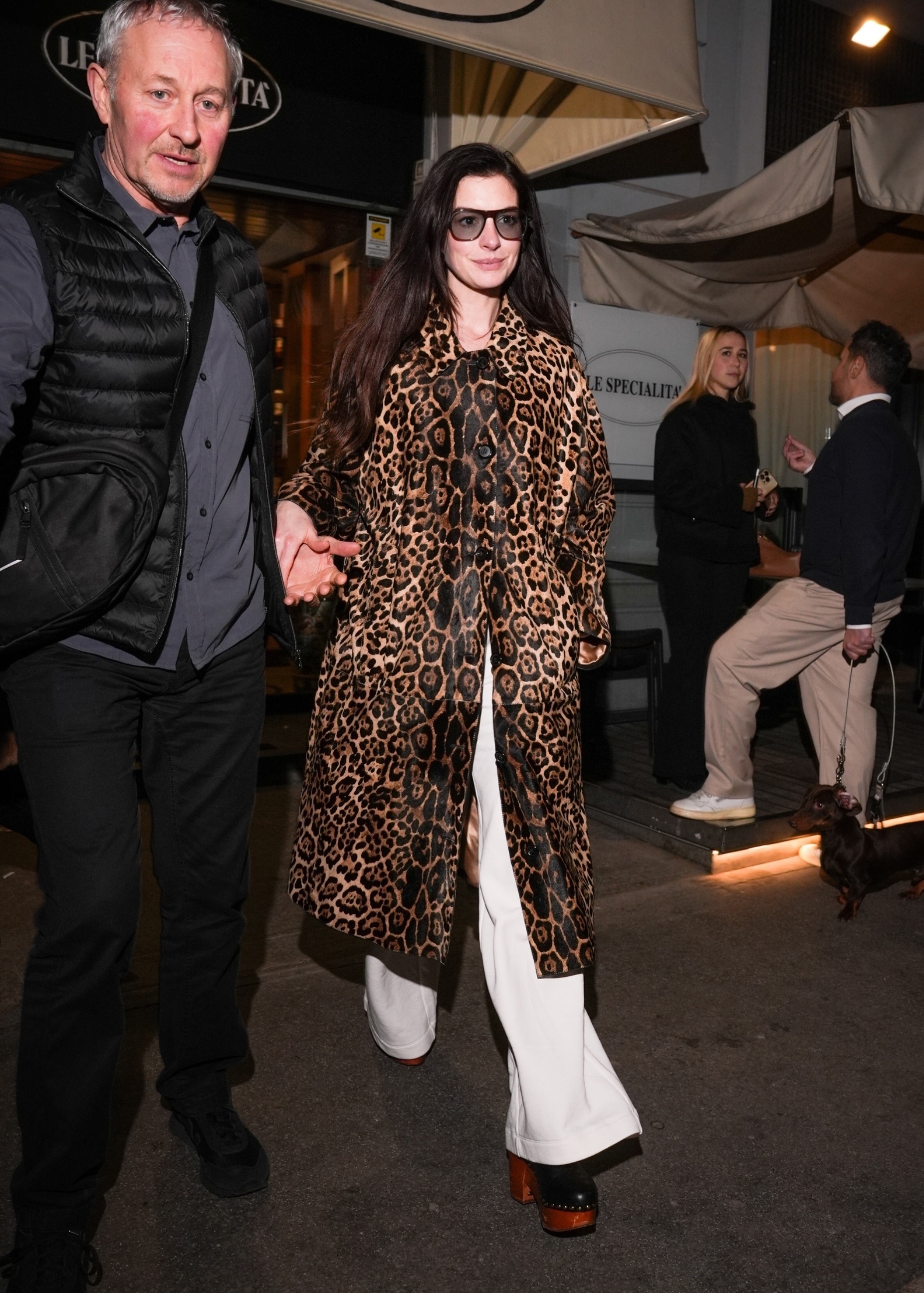 An image of Anne Hathaway wearing a leopard-print coat, white jeans and platform clogs whilst out in Milan.