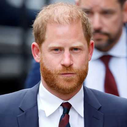 Prince Harry wearing a blue suit and striped tie