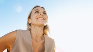 Woman looking up into sunshine