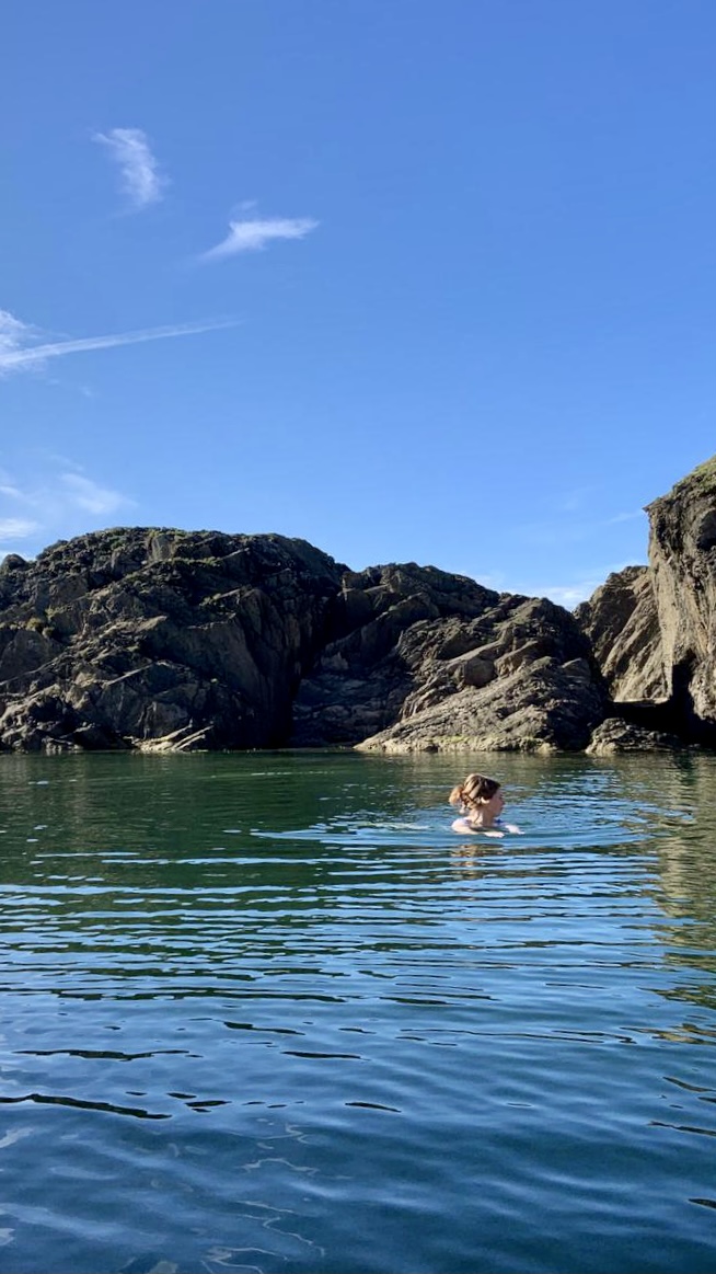 Rosie Paterson swimming in a calm lagoon surrounded by jagged rocks