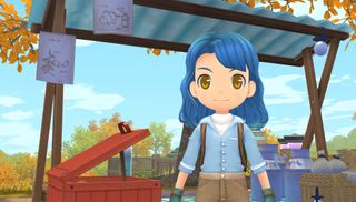 Story of Seasons - a player with blue hair and clothes stands in a market stall of boxes at the center of town