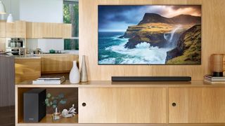 The Samsung Q70 QLED TV pictured mounted on a wall and displaying an image of waves crashing against cliffs