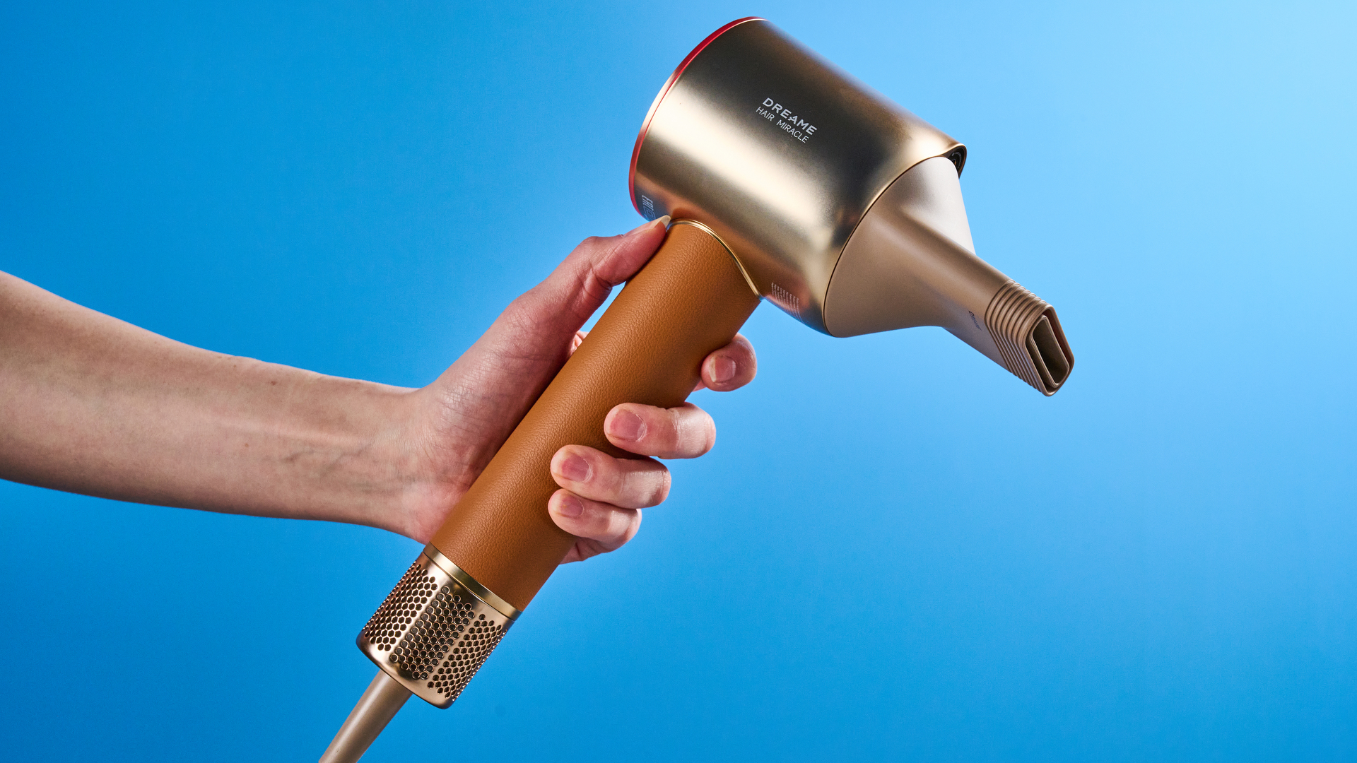 the dreame miracle pro hair dryer in gold showing the storage box on the blue tom's guide background, with the four attachment nozzles including two blow-drying nozzles, diffuser, and the flyaway tamer