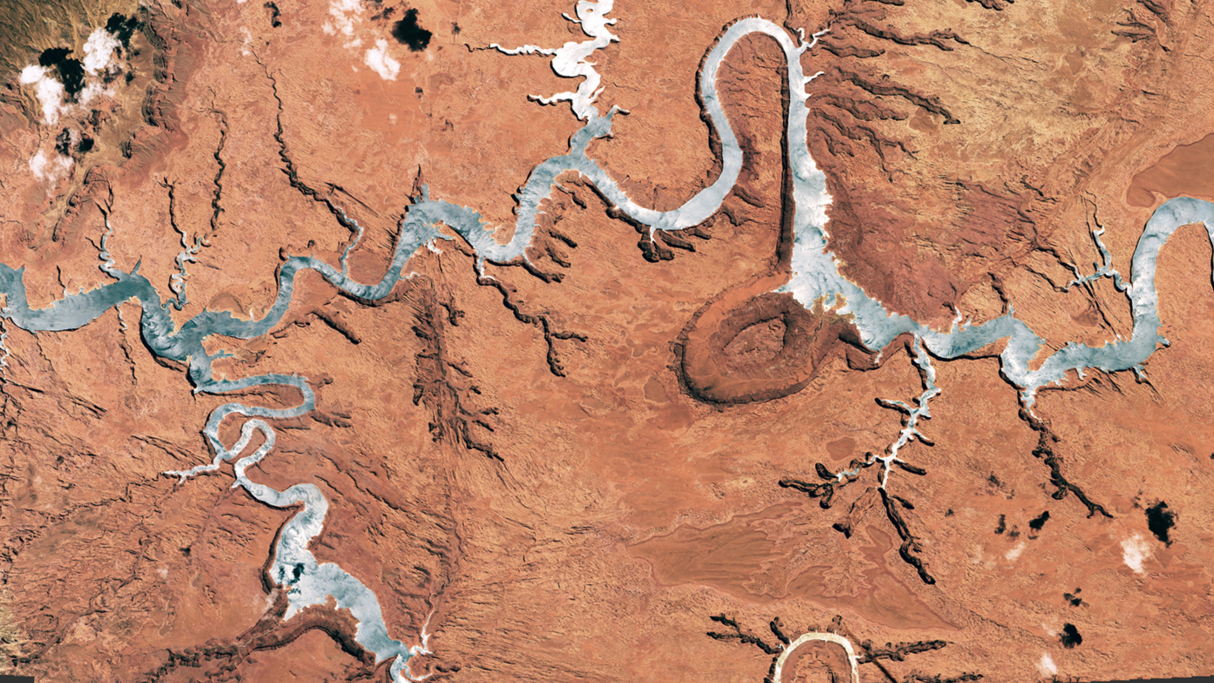 A satellite photo showing a giant river-like reservoir that has been turned silver by a sunglint 