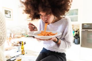 Gluten free foods: a woman eating pasta