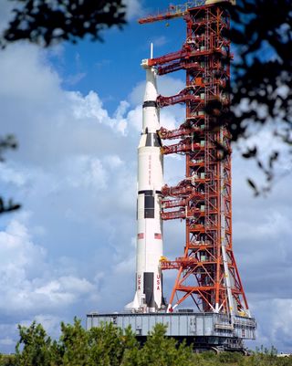 apollo 17 lunar landing mission, the Saturn V rocket stands on the transporter, held by a large red structure.