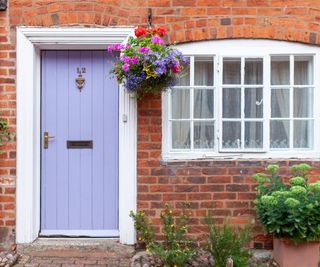 lilac painted front door on brick cottage style property