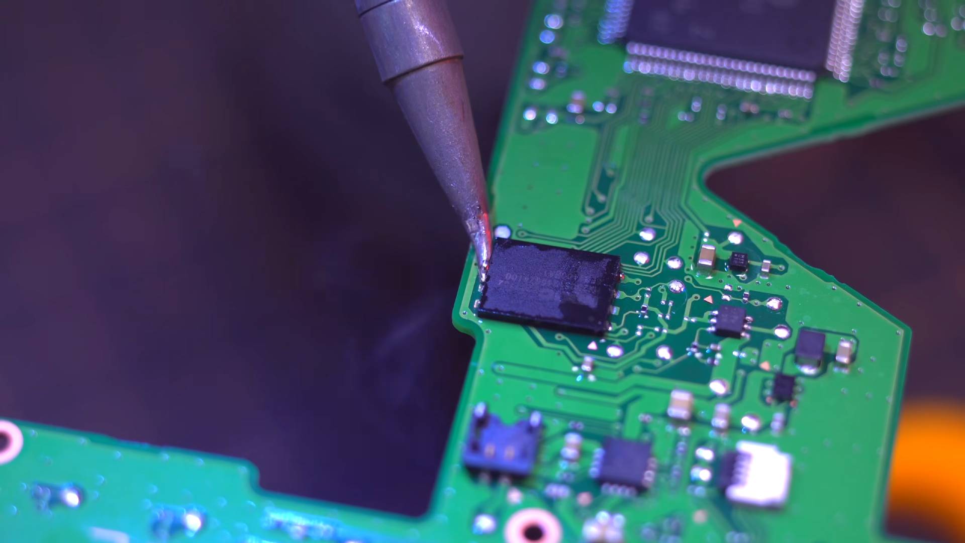 Close up of Macho Nacho Productions installing memory chip on Zelda Game and Watch motherboard.