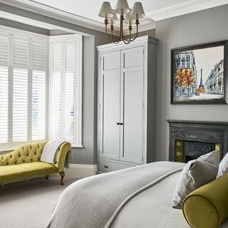 bedroom with grey cupboard and fireplace